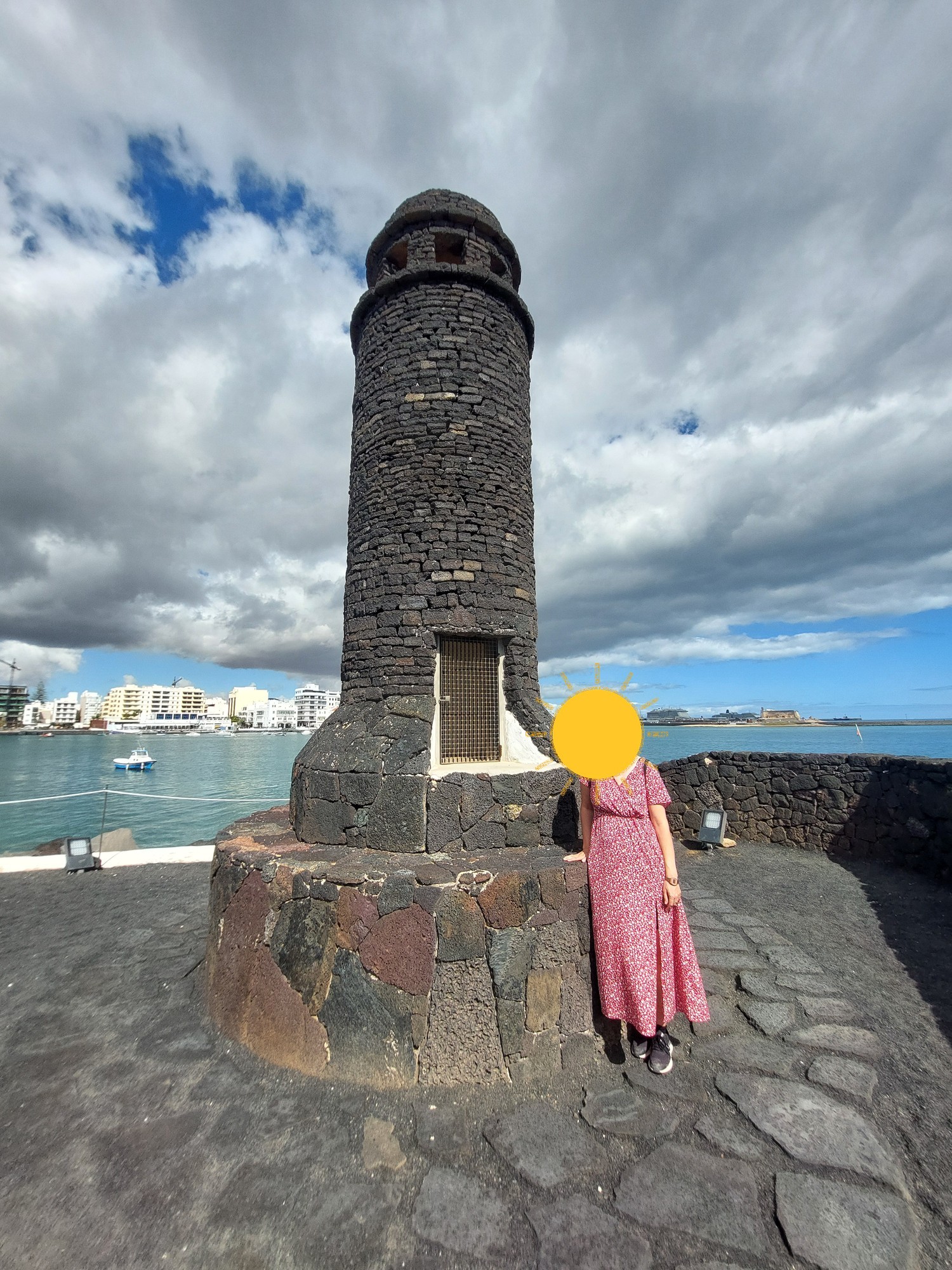 Steinturm auf einer kleinen Insel in Arrecife mit Blick auf die Stadt (Gesicht mit Sonne verdeckt)