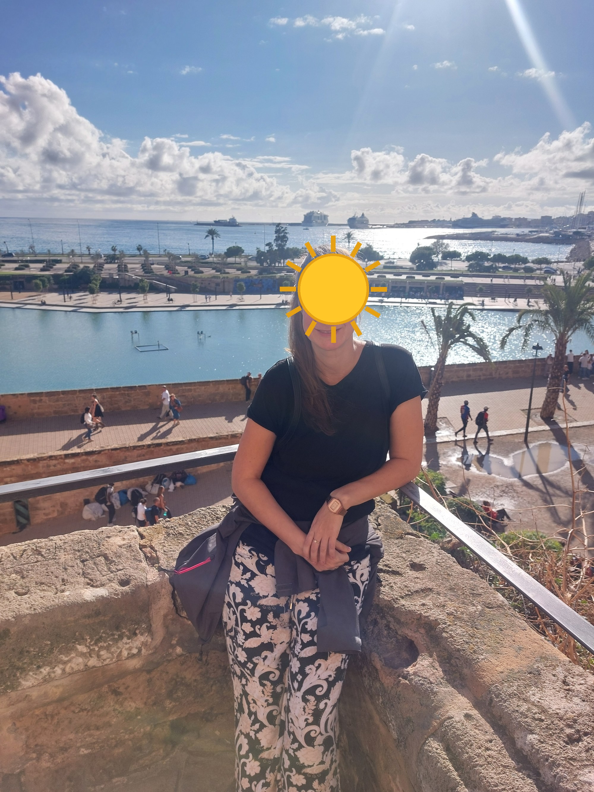 Nina auf der Stadtmauer mit Blick über den Hafen von Palma (Gesicht mit Sonne verdeckt)