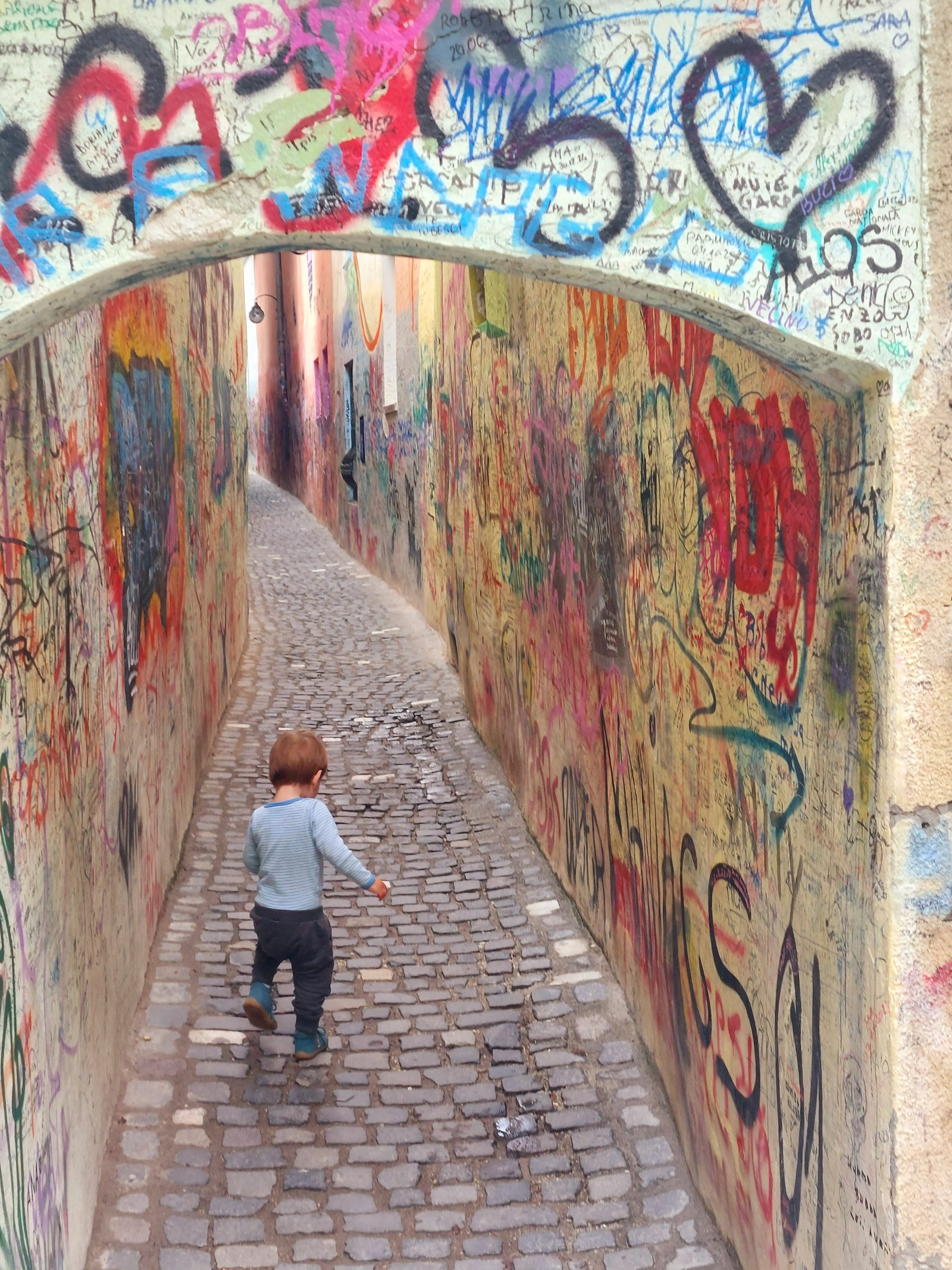 Lolo läuft durch die Strada Sforii in Brașov, die schmale Fadengasse mit Graffiti