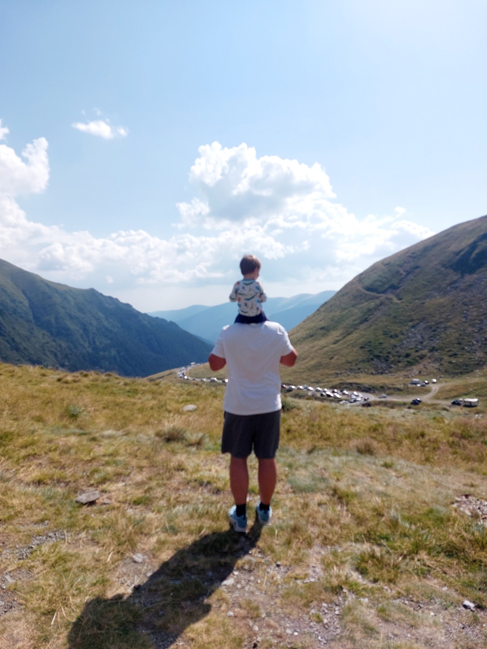 Papa trägt Lolo auf den Schultern mit Blick auf die Autoschlange an der Transfăgărășan