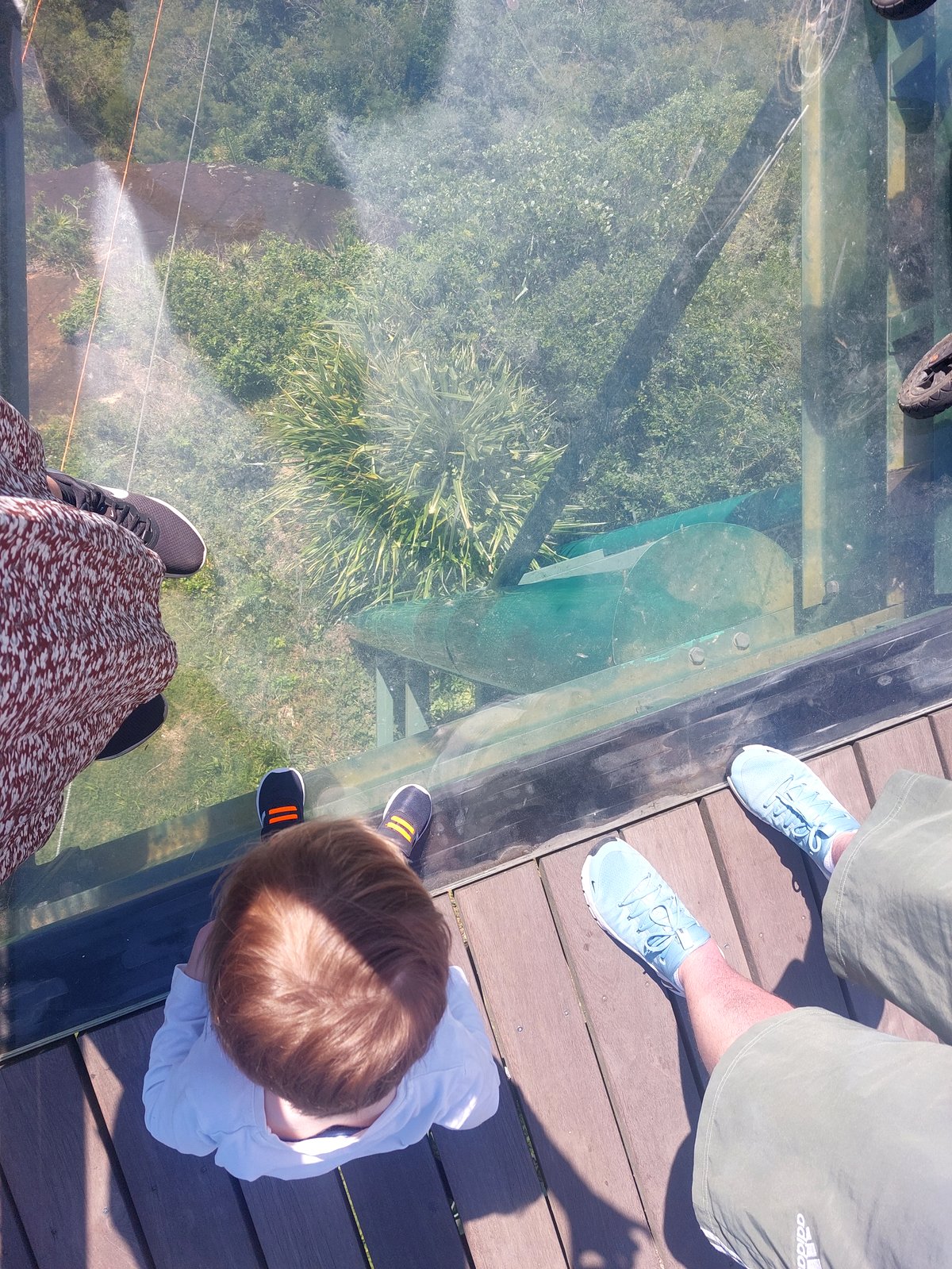 Familie auf der Glasplattform Parque Unipraias mit Blick nach unten durch den Boden