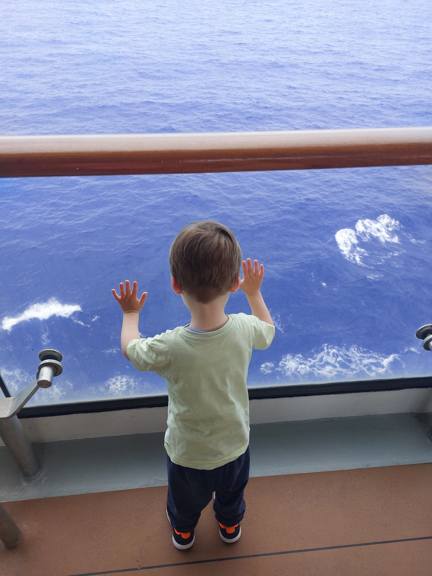 Lolo schaut vom Balkon aus auf das offene Meer